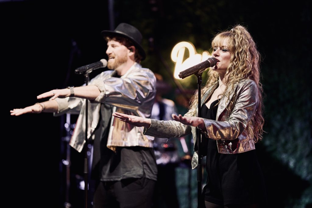 Sänger und Sängerin der Music Nau Now Liveband performen live auf der Bühne – energiegeladener Showact für Firmenfeiern, Galas und exklusive Events in NRW und Deutschland.