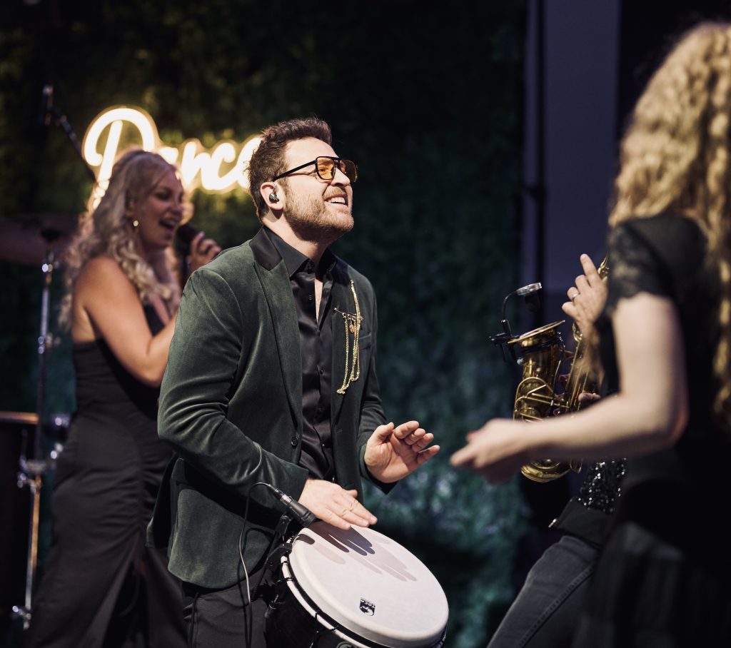 Percussionist und Mitbegründer von Music Nau Now mit Djembe auf der Bühne – mobile Live-Performance für Firmenfeiern, Galas und Events in NRW und ganz Deutschland.