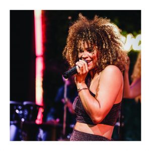 Sängerin Diana Schneider singt live mit Mikrofon auf einem Event in NRW – moderner DJ-Liveact mit Bühnenlicht.