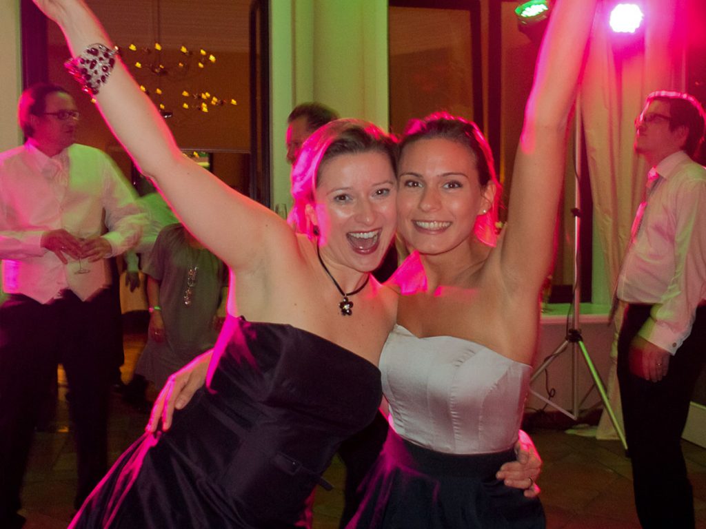 Das Foto zeigt zwei Hochzeitsgäste auf der Feier. Eine Hochzeit mit Eventband, DJ und viel Show der Musiker.