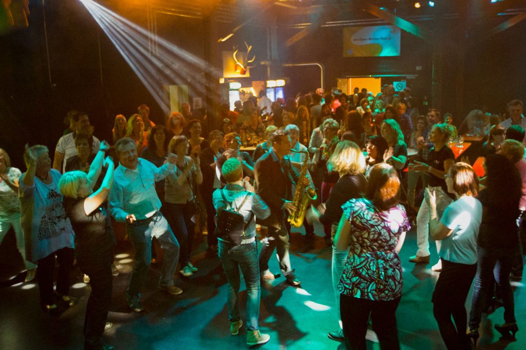 Tanzende Menschen in einem Club. Music Nau Now liefert die passende Musik mit Liveband und DJ auf einer Party in Düsseldorf