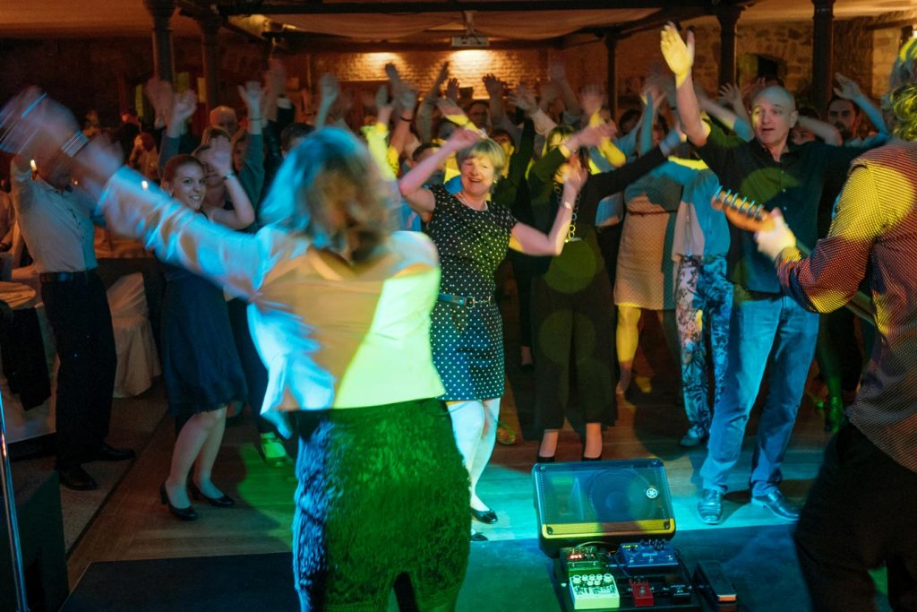 Begeisterte Gäste tanzen mit erhobenen Armen vor der Bühne bei einer Live-Performance von Music Nau Now