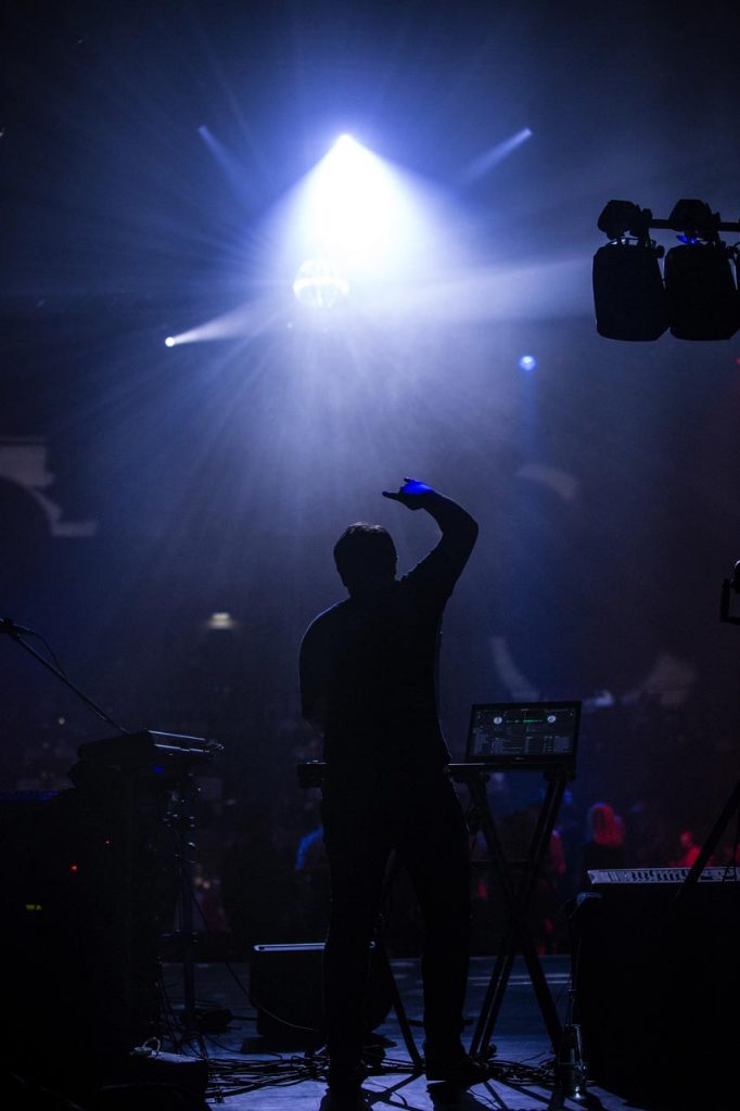 DJ der Eventband Music Nau Now als Silhouette auf der Bühne mit Lichtshow bei einem Corporate Event