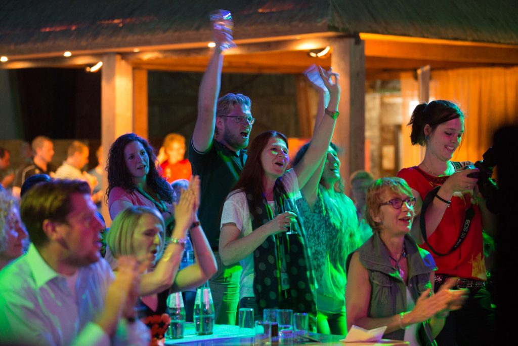 Feiernde Gäste applaudieren und jubeln bei einem Live-Showact von Music Nau Now.