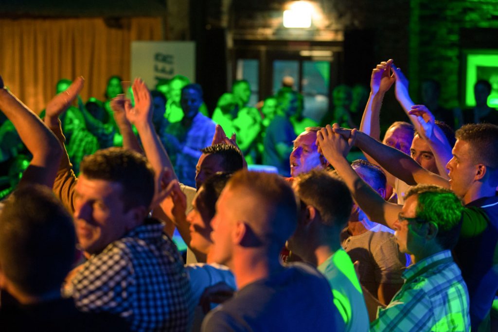 Feiernde Gäste mit erhobenen Händen vor der Bühne bei einem Showact der Eventband Music Nau Now.